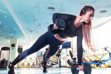 Female in gym doing strength training with dumbells