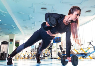 Female in gym doing strength training with dumbells