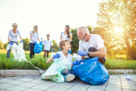 2 women, 1 man and 2 kids outside collecting litter to improve their charity efforts