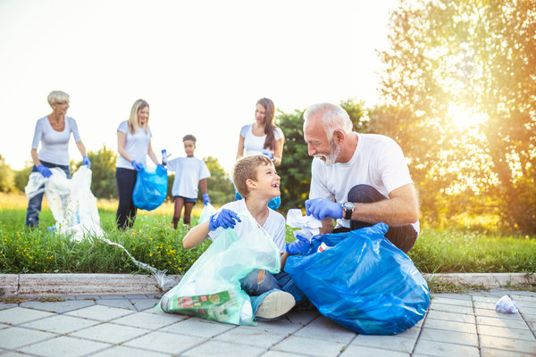 2 women, 1 man and 2 kids outside collecting litter to improve their charity efforts