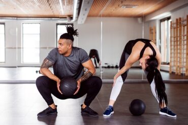 man and woman in a gym dong a HIIT workout together
