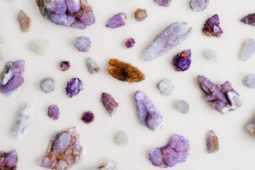 Assorted quartz and amethyst crystals arranged on a pale linen surface