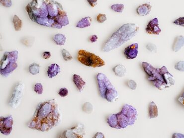 Assorted quartz and amethyst crystals arranged on a pale linen surface