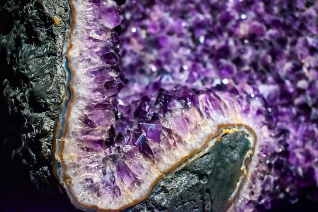 A raw amethyst geode photographed close up on a wooden shelf
